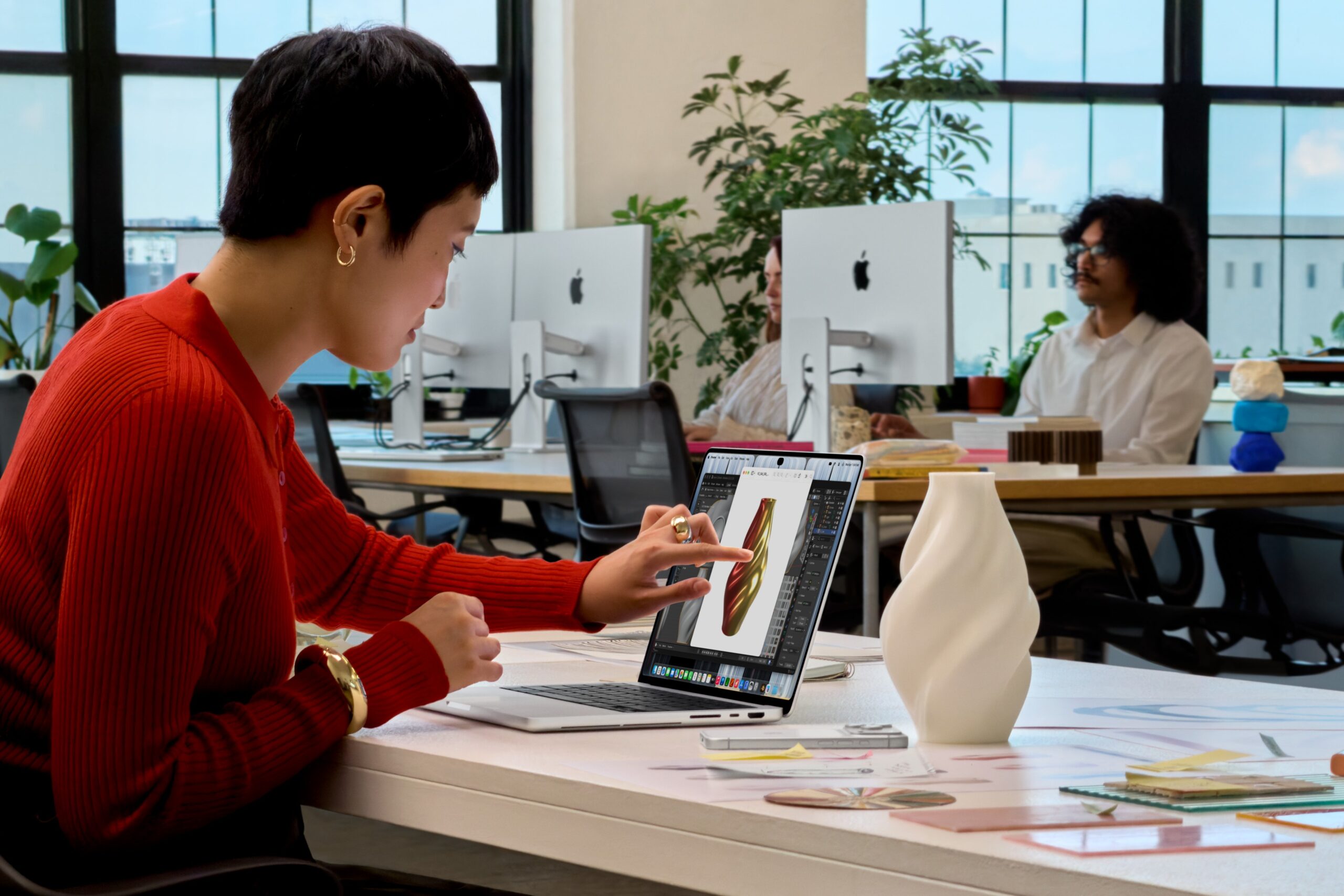 Apple showing how touchscreen can be used in a lifestyle office on the new MacBook Pro with PROLED XDR Display